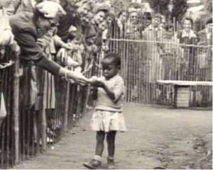 An African child in a Belgium zoo being fed with banana
