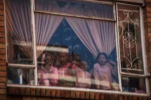 Children at window of a building in Hillbrow, Johannesburg. Children will be vulnerable if vaccinations are postponed. - Source: Photo by Marco LongariAFP via Getty Images