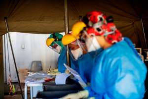 Health workers fill out documents before performing tests for COVID-19 at the screening and testing tents set up at the Charlotte Maxeke Hospital in Johannesburg. - Source: Photo by Michele Spatari  AFP via Getty Images