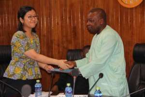 Agyeman Many right in a symbolic exchange of the document with Ms Maki after the signing