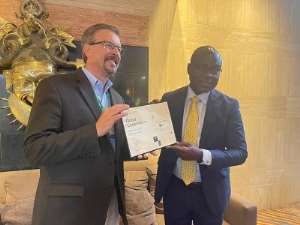 James P. Olshefskyanleft presenting a certificate to Prof. Alex Dodoo after the meeting