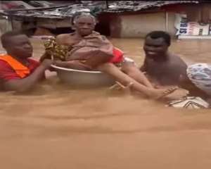 An older adult being taken to safety after being rescued from flood waters