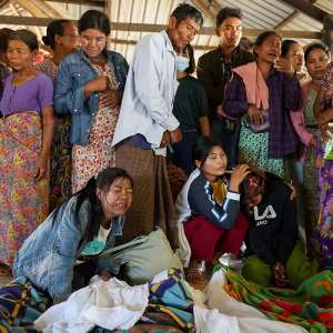 Mourners grieve as bodies are laid out at a cemetery before their burial following a Myanmar military air strike on a hospital that killed more than 30 people, in Mrauk U in northern Rakhine state, on December 11, 2025 AFP