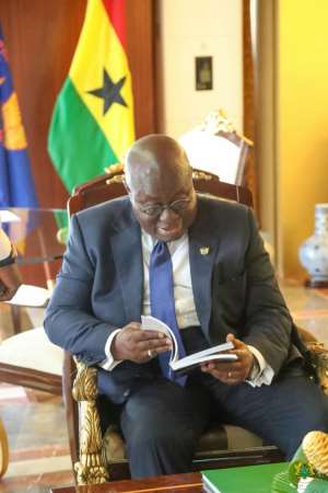 President Akufo-Addo glancing through Bola Rays Biography