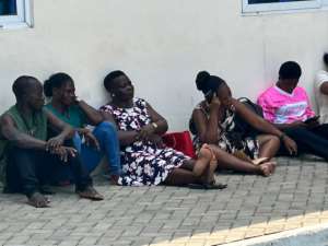 Frustrated parents sitting on bare floor in hope of securing placements for their wards
