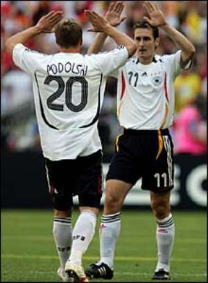 Podolski celebrates his second goal with Miroslav Klose, who played a big part in both of his strike partner's goals