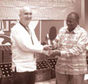 Mr. Greg Metcalf, MD Accra Brewery Limited symbolically presents a bottle of the award-winning beer to Ransford Tetteh GJA President when the brewery recently handed over assorted products in support of the Annual GJA Awards