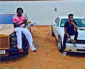 Emmanuel Adebayor left poses with his expensive car with Nigerian recording artist Wizkid right