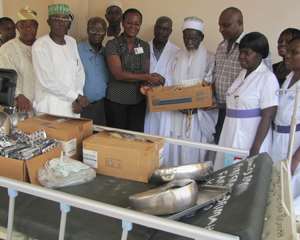 Sheikh Osman Nuhu Sharubutu presenting the medical equipment to Dr. Ivy Ekem as a representative of the family and others look on.