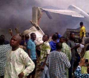 Residents of the Iju district of Lagos gathering at the site where a Dana company aircraft crashed.  By Ckn AFP