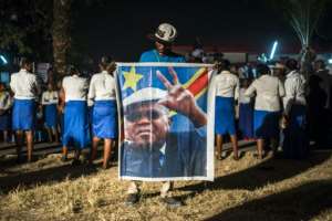 A supporter of the Democratic Republic of Congo's opposition leader Etienne Tshiskedi holds his portrait during a rally in Kinshasa in 2016.  By Eduardo Soteras AFPFile