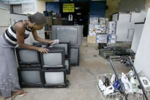 A saleswoman dusts used television sets at a second-hand market in Abidjan.  By Issouf Sanogo AFPFile