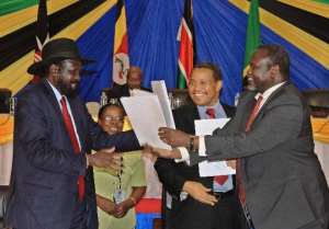 South Sudan's President Salva Kiir L exchanges signed documents with South Sudanese rebel leader Riek Machar in northern Tanzania's town of Arusha on January 21, 2015.  By  AFPFile
