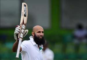 Hashim Amla raises his bat in celebration after scoring a century 100 runs during the third day of the second Test match between Sri Lanka and South Africa in Colombo on July 26, 2014.  By Lakruwan Wanniarachchi AFP