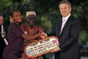 Tony Blair (right) receives a plaque after being made an honorary Paramount Chief in Mahera, Sierra Leone in 2007.  By LEON NEAL (AFP/File)