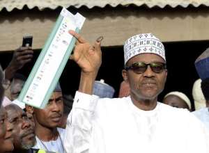 Main opposition All Progressives Congress APC presidential candidate Mohammadu Buhari holds up his ballot paper prior to voting in Daura, in northern Nigeria's Katsina State, on March 28, 2015.  By Pius Utomi Ekpei AFPFile