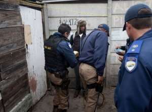 Cape Town metro police officers seize marijuana from two young men in Manenburg on August 27, 2013.  By Rodger Bosch AFP
