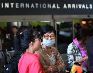A passenger arrives wearing a face mask at Los Angeles International Airport as fear of the Ebola virus continues to grow in the US on October 17, 2014.  By Mark Ralston AFP