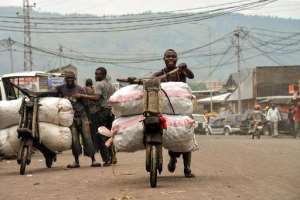 Men transport goods on tshukudus, wooden push-bikes, in Goma on June 18, 2014.  By Junior D. Kannah AFPFile