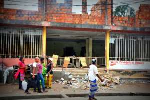 People walk past a looted store in Kinshasa on January 22, 2015.  By Papy Mulongo AFPFile