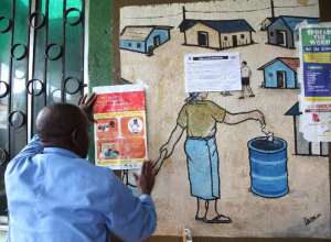 A nurse puts up an information sign about Ebola on a wall of a public health center on July 31, 2014 in Monrovia, Liberia.  By  AFP