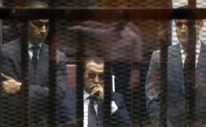 Former Egyptian leader Hosni Mubarak centre sits in the defendants cage flanked by his two sons Gamal left and Alaa aduring a previous court appearance in May 2015.  By Mostafa El-Shemy AFPFile