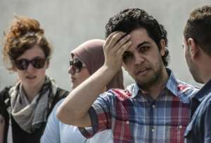 Newly freed Al-Jazeera news channel's journalist Abdullah Elshamy 2nd R stands outside the court during the trial of three of his colleagues for allegedly supporting the Muslim Brotherhood on June 23, 2014.  By Khaled Desouki AFP