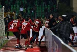 Egyptian Al-Ahly players escape from the field as fans of Al-Masry team rush to the pitch during clashes.  By  AFP