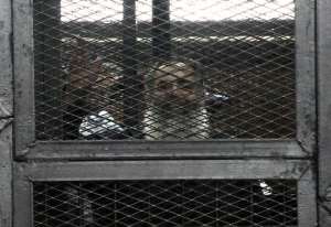 Salafi Islamist politician Hazim Salah Abu Ismail waves from inside the defendants cage during his trial in the Egyptian capital Cairo on April 16, 2014.  By Mohamed el-Sherpeny AFP