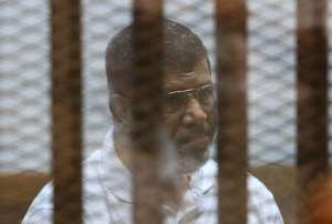 Egypt's deposed Islamist president Mohamed Morsi sits inside the defendants cage during his trial at the police academy in Cairo on August 18, 2014.  By  AFPFile