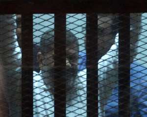 Egypt's former Islamist president Mohamed Morsi seen from the defendent's cage during his trial at a court in Cairo on April 21, 2015.  By Mohamed El-Shahed AFP