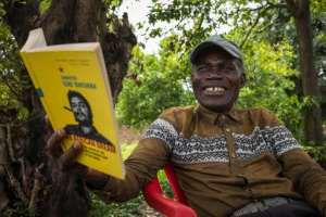 Congolese man Andre Shindano smiles after recognizing Cuban-Argentinian guerrilla leader Ernesto Che Guevara, whom he met as a boy, in a picture during an interview with AFP in Baraka.  By Federico Scoppa (AFP/File)