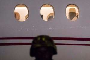 Former Gambia president Yaya Jammeh, the country's leader for 22 years, looks through the window from the plane as he leaves the country on January 21, 2017 from Banjul airport.  By STRINGER AFP