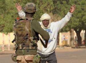 A Malian soldier arrests a man at a checkpoint on February 11, 2013, in Gao.  By Pascal Guyot AFP