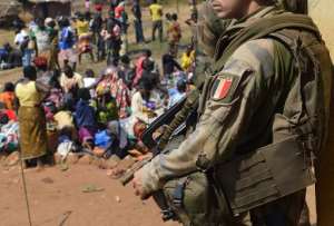 A French soldier taking part in 'Operation Sangaris' standing guard as Muslim people wait to seek refuge at the Boali church, some 100km north of Bangui.  By Eric Feferberg AFPFile