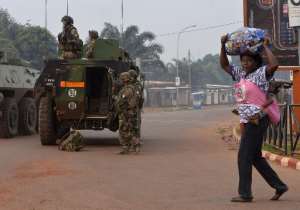 A woman with her child walk past French soldiers taking part in the Sangaris operation as they patrol in Banga district of CAR capital Bangui, on December 26, 2013.  By Miguel Medina AFP