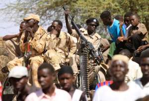 Sudanese soldiers keep watch as they sit next to civilians in the Shangil Tobaya area for displaced people in North Darfur state, on June 18, 2013.  By Ashraf Shazly AFPFile