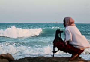 An armed Somali pirate keeping vigil on the coastline near Hobyo, northeastern Somalia, in 2010.  By Mohamed Dahir (AFP/File)