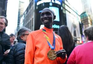 2014 New York City Marathon men's winner Kenyan Wilson Kipsang smiles as he poses with tourists in Times Square on November 3, 2014.  By Jewel Samad AFPFile