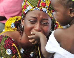 A young girl tries to comfort her mother during a burial ceremony.  By Sia Kambou AFPFile