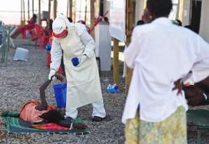 A health worker wearing protective equipment assists an Ebola patient at the Kenama treatment centre run by the Red Cross Society on November 15, 2014 in Sierra Leone.  By Francisco Leong AFPFile