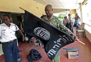 A Kenyan police officer folds up a flag inscribed with the logo of the Islamic state IS following a raid on two mosques in the coastal city of Mombasa, on November 17, 2014.  By  AFPFile