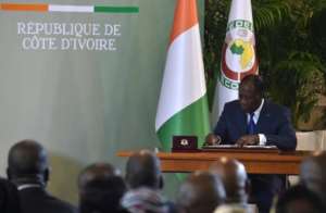 Ivory Coast's president Alassane Ouattara signs the country's revisited constitution on November 8, 2016 at the presidential palace in Abidjan.  By Issouf Sanogo AFP