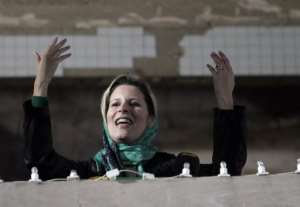 Aisha Kadhafi salutes a crowd gathered in her father's residence in Tripoli in April.  By Joseph Eid AFP