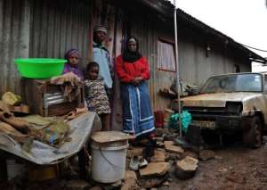 Latifah Naiman R stands with her children in front of her house in the Nairobi slum of Kangemi on August 3, 2013.  By Tony Karumba AFP