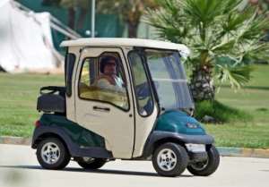 Libyan leader Moamer Kadhafi drives a golf buggy in Tripoli earlier this month.  By Mahmud Turkia AFP