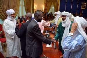 Members of the Malian and Tuareg delegations shake their hands after signing an agreemen, June 18, 2013, in Ouagadougou. By Ahmed Ouoba (AFP)