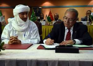 Algerian Foreign Minister Ramtane Lamamra R sign documents overseeing a peace agreement between the Malian government and armed groups on February 19, 2015 in Algiers.  By Farouk Batiche AFP