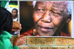 Pictures of former South African President Nelson Mandela are hung up at a mass prayer meeting in Cape Town on June 27, 2013.  By - AFPFile