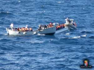 Migrants sit in a boat during a rescue operation off the coast of Sicily in early December.  By  Italian NavyAFPFile